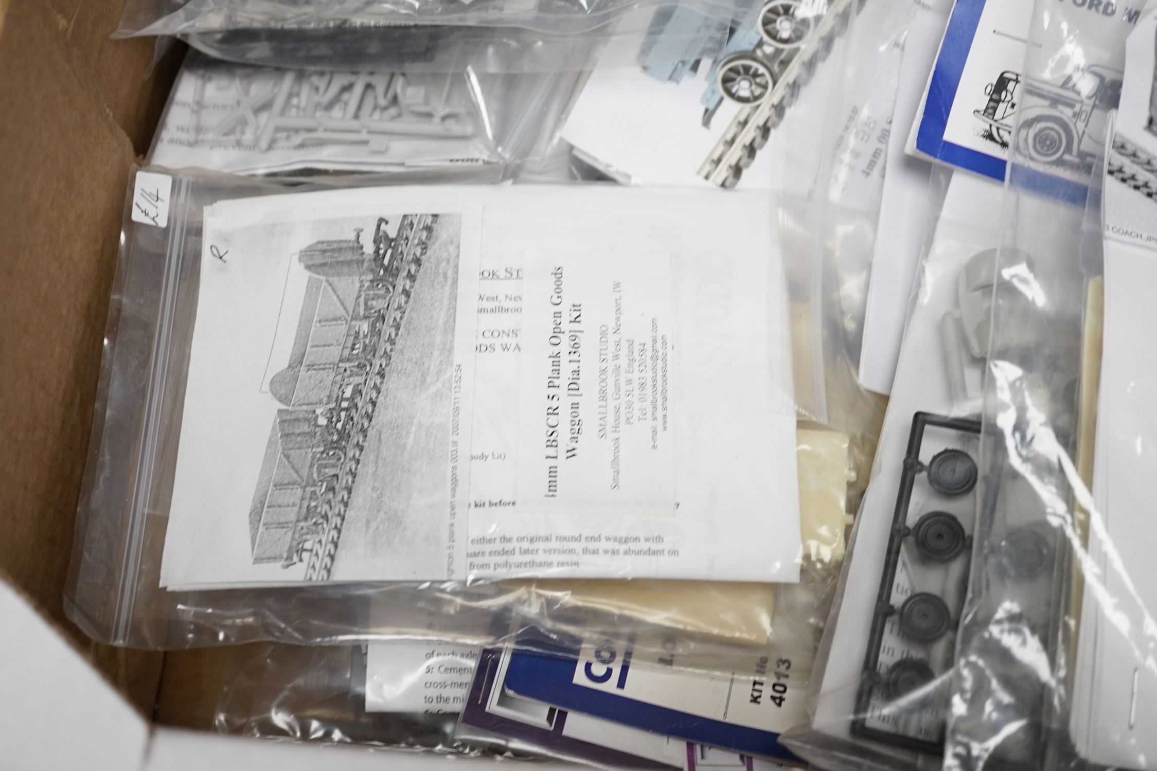 A collection of unmade, 4mm scale 00 gauge model, railway kits, and lineside accessories, including freight wagons, four-wheel coaches, commercial vehicles, etc. by Dapol, Cooper Craft, Parkside Dundas, etc. together wit